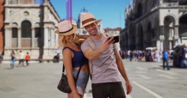 St. Mark Meydanı 'nda selfie çeken seksi genç bir çift. Mutlu ve şık bir çift Venedik 'te fotoğraf çekiyor. 4k