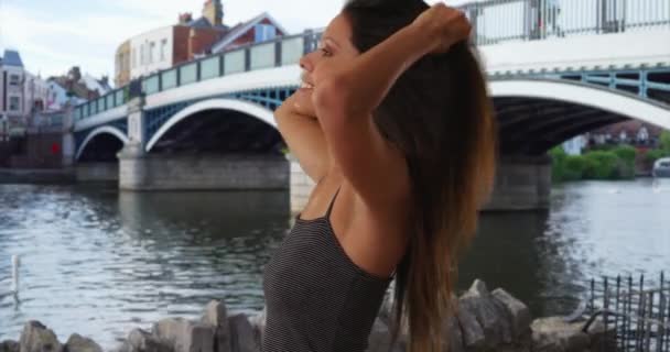 英国温莎的泰晤士河边 一位年轻的观光客正在享受微风 漂亮的白种人女孩穿着条纹背心在英国度假 — 图库视频影像