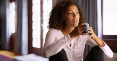 Oturma odasında oturmuş pencereden dışarı bakan neşeli çift.