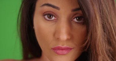 Ateşli Latin bir kadının yeşil ekranda kendine güvenen bir şekilde kameraya bakması. Anahtar ya da birleşik olmak üzere yeşil ekranda.