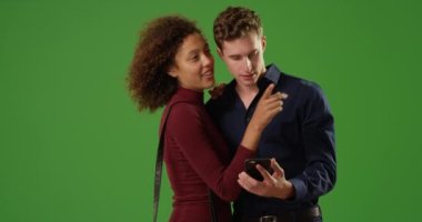 Genç romantik çift yeşil ekranda yön bulmak için akıllı telefon GPS 'i kullanıyor. Anahtar ya da birleşik olmak üzere yeşil ekranda.