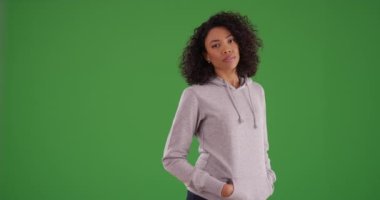 Güzel siyah kadın soluklanıyor ve yeşil ekranda gözlerini kapıyor. Kapüşonlu kapüşonlu Afrikalı Amerikalı kadın kameraya bakıyor ve yeşil ekranda mutlulukla gözlerini kapıyor. 4k