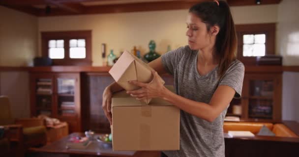 漂亮的白人女人在客厅里提着装运箱 20多岁的年轻女性在屋里拿着箱子准备装运 — 图库视频影像