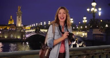 Seyahat fotoğrafçısı, Pont Alexandre III Köprüsü 'nün fotoğraflarını çekiyor. Paris 'te muhteşem bir gecede kameralı bir kadın turist. 4k