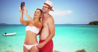 Mutlu milenyum çifti sahilde selfie çekiyor. Mutlu milenyum kadınları, su kenarında seksi sevgilileriyle selfie çekiyorlar. 4k