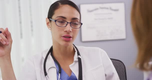 아름다운 의사가 사무실에서 환자와 이야기하는 매력적 바닷말 의사가 계획에 와대화하는 — 비디오