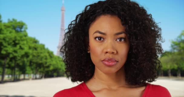 パリ旅行中に顔を真剣に見ているアフリカ系アメリカ人女性 エッフェル塔の近くのフランス パリの外で誰かを探している黒人の若い女性 — ストック動画