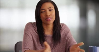 Güzel bir Afro-Amerikalı kadın sanki röportaj yapılıyormuş gibi kameraya konuşuyor. Zeki, iyi konuşulan iş kadını sohbet ediyor, dostça gülümsüyor. 4k