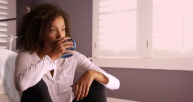 Düşünme ve kahve bardağı içme çekici genç siyah kadın