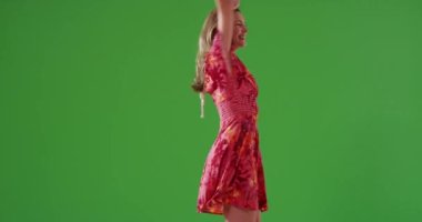 Çekici orta yaşlı beyaz kadın yeşil ekranda dans ediyor. Anahtar ya da birleşik olmak üzere yeşil ekranda.