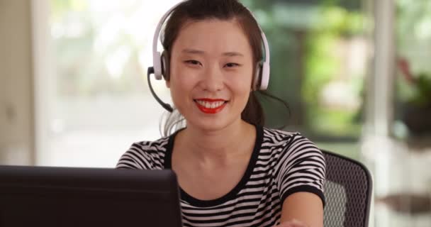 Szczęśliwy Azjatycki Operator Telefonu Obsługi Klienta Słuchawkami Mikrofonem Uśmiechnięty Kamery — Wideo stockowe