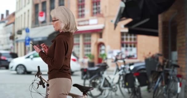 Mujer Caucásica Mayor Activa Con Mensajes Texto Bicicleta Acera Bike — Vídeo de stock
