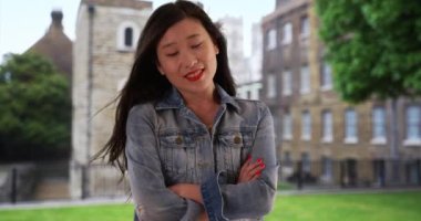 Londra 'da tatildeyken kolları çaprazlanmış kot ceketli Çinli bir kadın. Asyalı milenyum turisti İngiltere 'de tatil yapıyor. 20 'li yaşlarda, saçları rüzgarda uçuşan genç bir bayan. 4k