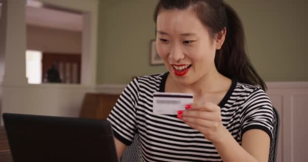 使用信用卡上网购买笔记本电脑的千年女性购物者的近景 在网上付账的年轻亚洲女人坐在家中餐桌前的肖像 — 图库视频影像