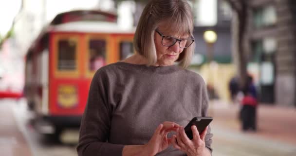 Σοβαρή Ηλικιωμένη Γυναίκα Που Χρησιμοποιεί Smartphone Για Διαβάσει Περισσότερα Από — Αρχείο Βίντεο