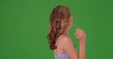 Çekici orta yaşlı beyaz kadın gülümsüyor ve yeşil ekranda eğleniyor. Anahtar ya da birleşik olmak üzere yeşil ekranda.