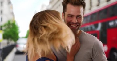 Londra caddesinde neşeli genç bir çiftin sıradan portresi. Açık havada gülümseyen ve gülen seksi beyaz erkek ve kadın. 4k