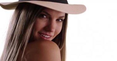 Beyaz fotokopi odasında şapkalı bir kadının arkasını kolladığı yakın plan. 20 'li yaşlarda güzel bir kadın kameraya bakıyor ve arka planda gülümsüyor. 4k