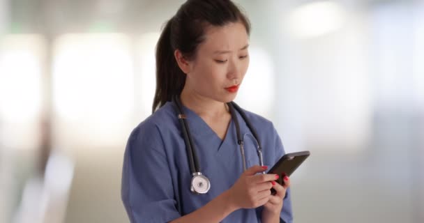 Poważny Milenijny Lekarz Czytający Sms Smartfonem Pustej Klinice Zbliżenie Młodej — Wideo stockowe