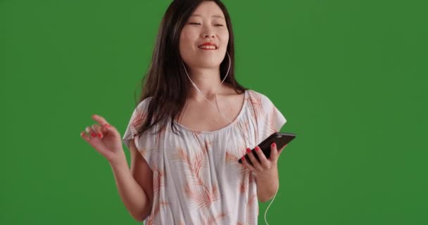 Nette Asiatische Frau Trägt Kopfhörer Und Hört Musik Auf Grünem — Stockvideo