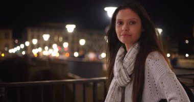 Çizgili fularlı turist kadın Florence City caddesinde göz teması kuruyor. İtalya 'da sırt çantalı güzel bir kadının portresi, rüzgarda savrulan saçlar. 4k