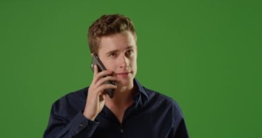 Günlük beyaz erkek iş kıyafetleri içinde yeşil ekranda akıllı telefondan konuşuyor. Anahtar ya da birleşik olmak üzere yeşil ekranda.
