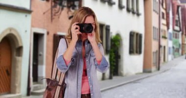 Bayan gezgin ya da fotoğrafçı şehrin dışında fotoğraf çekiyor. Güpegündüz köyde fotoğraf çeken neşeli bir turist. 4k