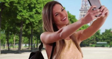 Mutlu milenyum kızları Paris, Fransa 'da seyahat ederken akıllı telefonlarıyla selfie çekerler. 20 'li yaşlarda beyaz bir kadın Eyfel Kulesi' nde telefonla fotoğraf çekiyor. 4k