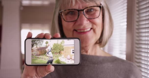 Senhora Gentil Mostrando Imagens Smartphones Sua Família Jogando Quintal Encantadora — Vídeo de Stock
