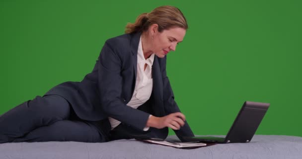 緑の画面上のノートパソコンやスマートフォンで働くビジネススーツの女性 緑の画面でキーまたは構成されます — ストック動画