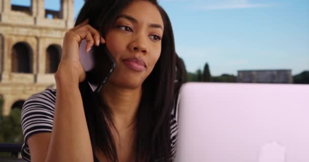 アフリカ系アメリカ人のビジネス女性で ローマにノートパソコンを持ち 海外電話をかける 休暇で働く黒人女性が上司に電話して成功した — ストック動画