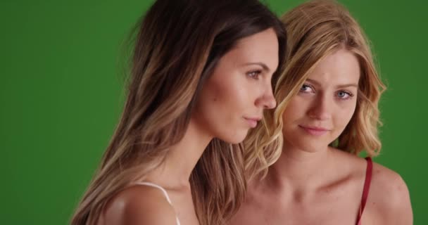 两名漂亮女子在绿色荧幕上的特写 两个可爱的女孩在室内绿屏演播室里凝视着忧郁的表情 — 图库视频影像