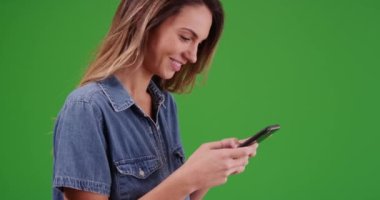 Yeşil ekranda akıllı telefondan mesajlaşan çekici milenyum kızlarının yakın çekimi. Anahtar ya da birleşik olmak üzere yeşil ekranda.