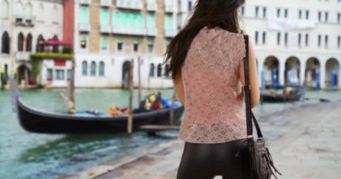 Beyaz bir kadının Büyük Kanal 'da mesajlaştığı dikiz görüntüsü. Venedik 'teki akıllı telefondan milenyum turistlerinin mesajları. 4k