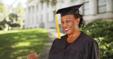 Üniversiteden mezun olan yaşlı siyahi bir kadın. Üniversiteden mezun olmuş yaşlı siyahi bir kadının portresi. 4k