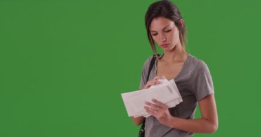 Beyaz bir kadın yeşil ekranda aldığı mektuplara ve mektuplara bakıyor. Milenyum kızı postalamadan önce zarf yığınını kontrol ediyor. Tuşlama veya birleştirme için yeşil üzerine 4K