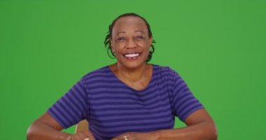 Yeşil ekranda kameraya gülümseyen yaşlı siyah bir kadın. Anahtar ya da birleşik olmak üzere yeşil ekranda.