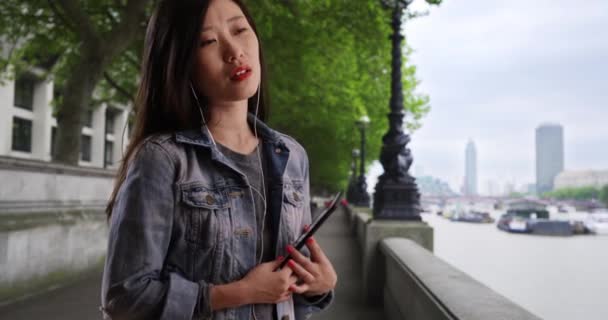 Mladá Žena Která Poslouchá Hudbu Chytrým Telefonem Sluchátky Thames River — Stock video