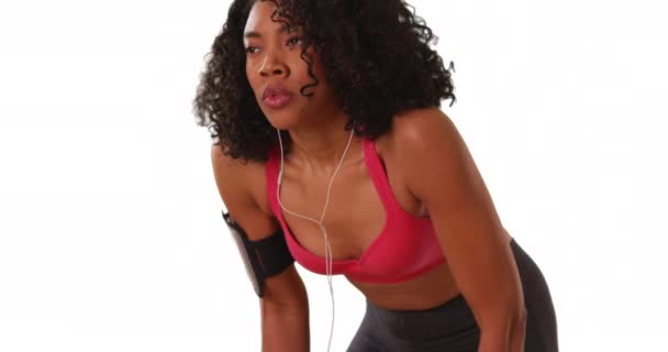 强壮的黑色女慢跑者在白色背景上 跑出屏幕 女运动员呼吸急促 带着版权去演播室跑步 — 图库视频影像