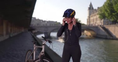 Paris 'te bisiklet sürmekten istirahat eden bir kadın. Sağlıklı bisikletçi, fitness izleyicisinin durumunu kontrol ediyor. 4k