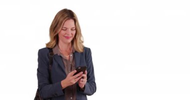 Beyaz arka planda gülümseyen orta yaşlı beyaz iş kadını akıllı telefondan mesaj atıyor. Stüdyoda cep telefonuyla mesaj atan mutlu ofis çalışanı. 4k