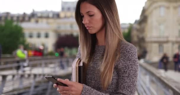 Millennial Woman Student Texting Phone While Holding Books Bridge Paris — Stock Video