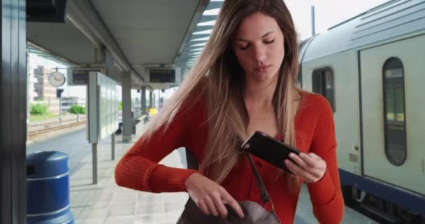 가방에서 전화기를 문자를 보냈습니다 여자가 기차역에서 기다리면서 문자에 답장하기 가방에서 — 비디오