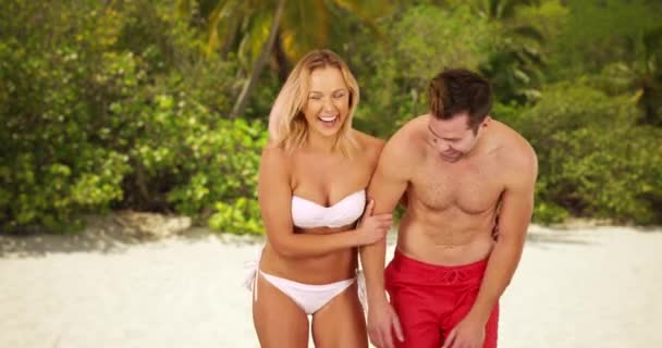 可爱的千年夫妇站在海滩边笑着 一对年轻的白人夫妇站在沙滩上玩乐 — 图库视频影像