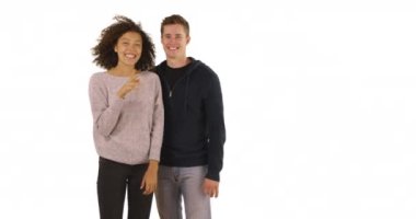 Beyaz arka planda yeni evin anahtarlarını taşıyan genç evli bir çiftin portresi. Yeni ev sahipleri stüdyoda kameraya telif hakkı ile gülümsüyor. 4k