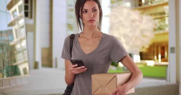 Şehir Merkezinde Posta Paketini Tutarken Cep Telefonu Kullanan Bir Kadın — Stok video