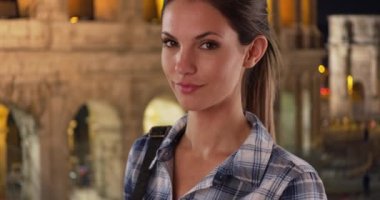 İtalya, Roma 'da iken ekose gömlekli çekici beyaz kadın portresi. 20 'li yaşlarında güzel bir kız Roma' da Coliseum 'un kamerasına bakıyor. 4k