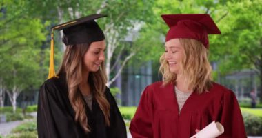 Üniversiteden mezun olan iki güzel kız öğrenci. Üniversite arkadaşları mezuniyet törenine hazırlanıyor. 4k