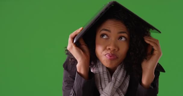 雨中的妇女躲藏在笔记本电脑下 作为掩蔽在绿屏上的地方 网络安全 技术和网络安全概念 黑人妇女使用Pc作为绿色屏幕上的保护 — 图库视频影像