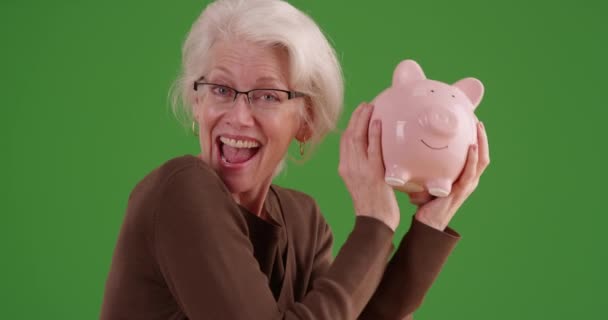 Veselá Starší Žena Třese Prasečí Bankou Usmívá Kameru Zeleném Plátně — Stock video